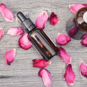 Rose Essential oil bottles surrounded by rose petals