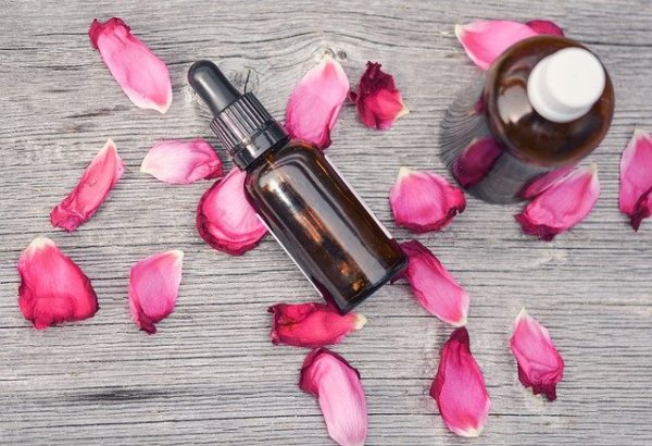 Rose Essential oil bottles surrounded by rose petals